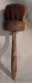 A vintage wooden handled pastry brush with a thin turned handle and horsehair bristles.