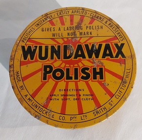 A flat round vintage Wundawax Furniture Polish tin with a removable lid and polish contents inside. 