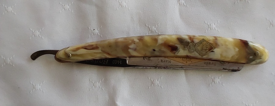 A vintage Gold steel Krone 1400 Bonsa Cut Throat Shaving Razor with a tortoiseshell type plastic handle.
