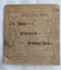 A small square faded green school Drawing Book with a decorative lined and patterned front cover.