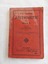 A red covered Arithmetic book for Grade V with the title, editor and publisher details printed and enclosed with a black lined border around the edges of the front cover.
