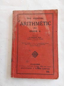 A red covered Arithmetic book for Grade V with the title, editor and publisher details printed and enclosed with a black lined border around the edges of the front cover.