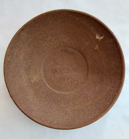 A round rusted tinplate weighing dish used at the top of kitchen weighing scales to weigh food.