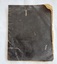 A black covered school exercise book with arithmetic, spelling, grammar handwritten in black ink.