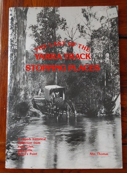 A large paperback book with a black and and white photograph of a covered wagon drawn by two horses crossing a flooded track in the bush. 