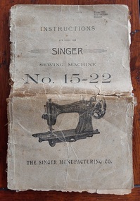 A damaged brown paperback Instruction Book for a Singer Sewing Machine 15=22, 1900 reissue.