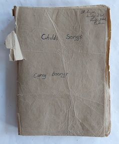An old red cloth soft covered music book with a homemade brown paper cover.