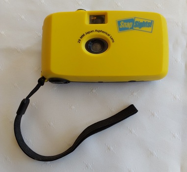 A 28mm Japan Aspherical Lens Snap Sights! reusable point-and-shoot camera encased in a yellow and black, rugged plastic housing with a black flat cotton carry cord. 