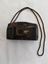 A black plastic lightweight no brand 35mm Optical Lens automatic focus camera with a black woven cotton neck cord attached with a bslck vinylcase.