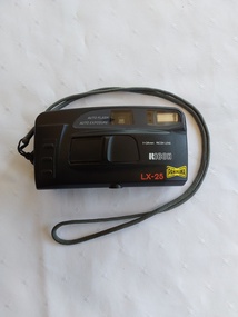 A RICOH LX-25 Panorama camera made of black plastic with a grey cotton cord holder connected to a black vinyl carry case.