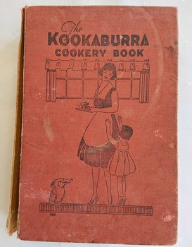 This red covered book has the title in black lettering and an illustration of a woman wearing an apron holding a dessert with a child beside her.