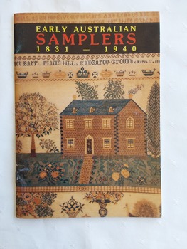 A book titled Early Australian Samplers 1831 - 1940 showing on the front cover a coloured photograph of a house and garden from an incomplete coloured sampler.