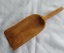 A vintage rough handmade wooden scoop for use with cooking ingredients.