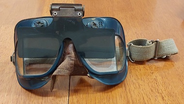 A pair of glass lens blue metal framed pilot issue RAF MK VII Flying Goggles used in WW11,with clip-on flip-up anti-glare sunshades.