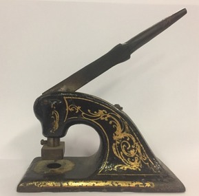 Black, cast iron stamp press with hand painted gold filigrees. Note the receiving plate is not present in this photo 