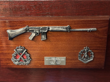 Memorabilia - rifle symbol mounted onto the wood board