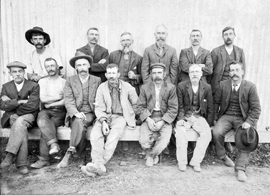 Photograph: Group on men on/behind wooden bench