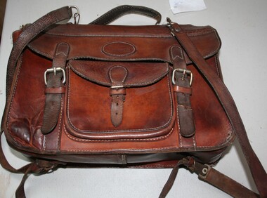 Leather satchel with shoulder straps for carrying on a persons back. Manufactured by Holden and Frost