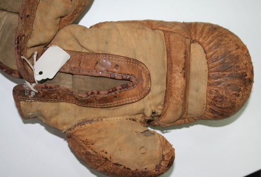Brown leather sporting boxing gloves with laced wrist.