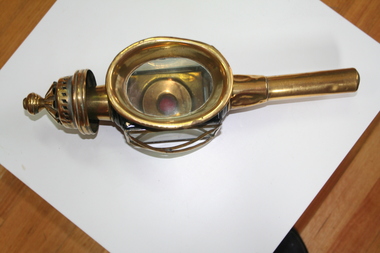 Brass coach lamps clear glass sides with metal cross bars for protection. Transparent red dimple at rear.