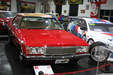 Red with Beige vinyl roof, quad headlamps chrome grille and bumper.