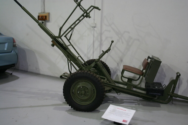Mobile multi shot machine cannon, military green in colour., seat for operator at rear.