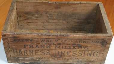 Open wooden box labeled as Frank Milers Harness dressing