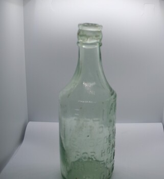 Clear glass bottle with inscription moulded on