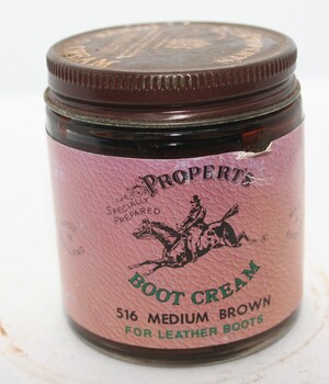 Small glass jar with metal screw on lid, paper label with instructiona