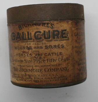 Short tin can with press on lid, paper label showing instructions