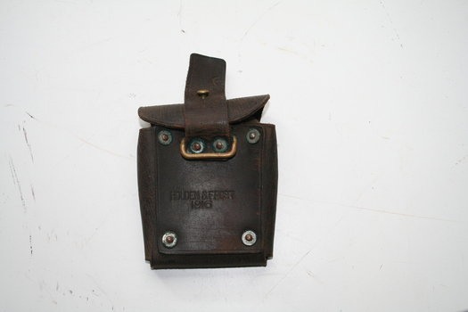eather pouch for mounting on belt, reverse facing cover with holding strap under cover