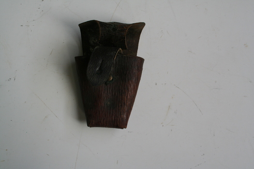 Brown leather pouch with lid to cover over. Leather strip riveted to rear, allowing pouch to be carried on a bandolier or belt