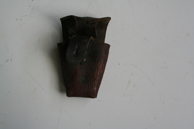 Brown leather pouch with lid to cover over. Leather strip riveted to rear, allowing pouch to be carried on a bandolier or belt