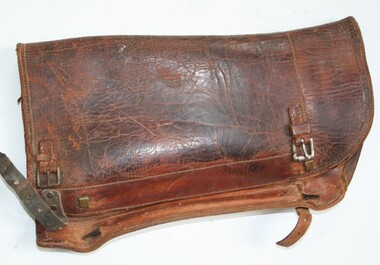 Brown leather legging with side opening closed by two leather straps and buckles