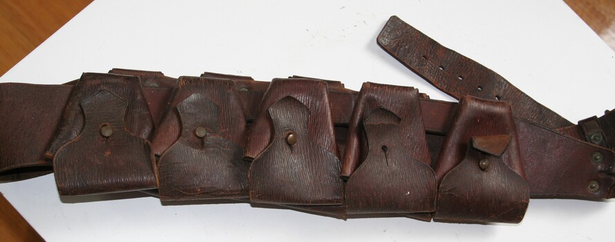 Brown leather strap with nine ammunition pouches worn on waist or over shoulder