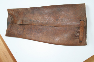 Brown leather leg gaiter buckle at top for fastening