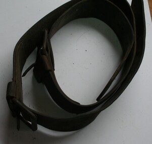 Brown leather belt with buckles and straps either end for fastening to cart poles