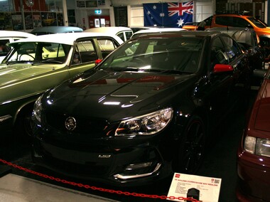 Black Holden sedan with red side mirrors