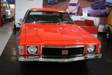 Mandarin Red 2 door Coupe, rectangular grille with pronounced chrome bumpers. Indicators and side lights were mounted together on the leading edge of the quarter panel.