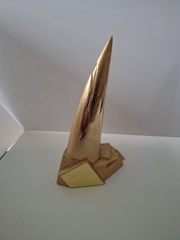 Gold plated metal trophy angled to a point on solid base