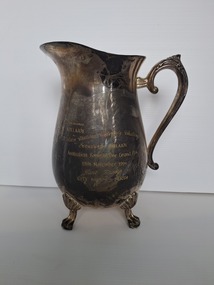 brass jug with four feet and handle