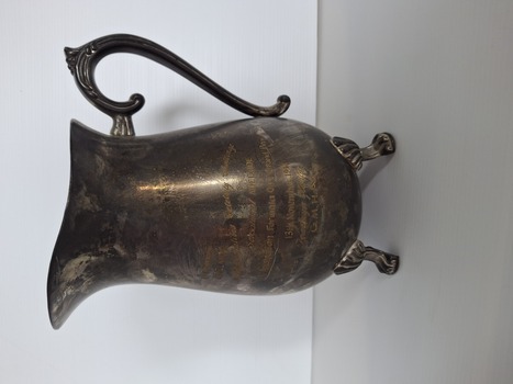 brass jug with four feet and handle