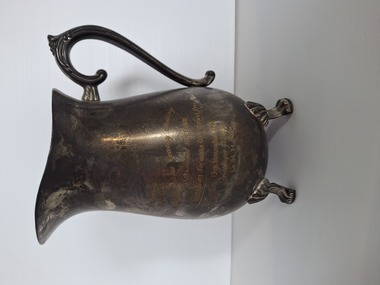 brass jug with four feet and handle