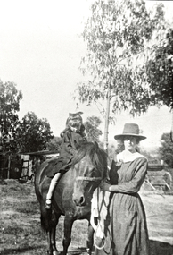 Photograph (Item) - Black and White, Wonga Park: Mrs Sharp standing with daughter Elizabeth on horse c. 1920