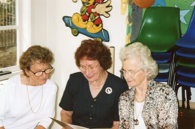 Photograph, Three ladies looking leaflet at Park Orchards Community House