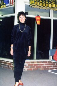 Photograph, Lady posing near windows that have ladies' tennis pennant flags