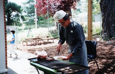 Photograph, Man cooking on a BBQ at Park Orchards Community Centre, Unknown year
