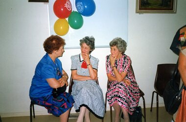 Photograph, Three people talking at a birthday at Park Orchards Community Centre, Unknown date