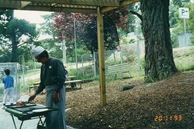 Photograph, Man cooking outside at Park Orchards Community House, 20th November 1993