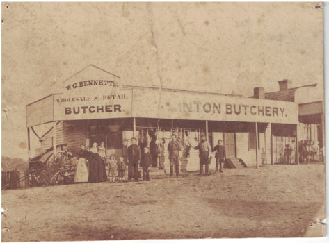 People standing outside butcher shop.